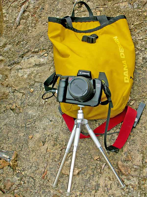 photo of a camera, tripod and wet bag which is one of the top tips and ideas for camping enthusiasts