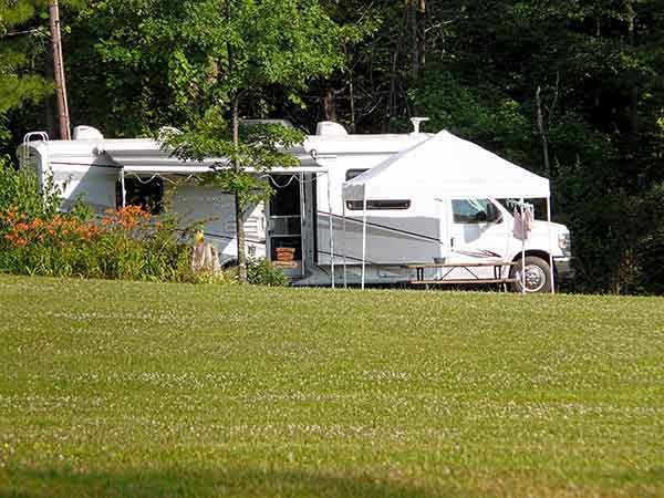 photo of how to make camping easier through technology with an RV and outdoor sun/rain protection tent