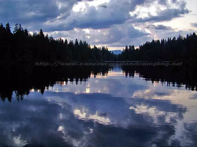 A brilliant photo of the sun light reflecting off the clouds into the calm waters of Paterson Lake 