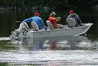 photo of 3 campers in their boat fishing on a lake