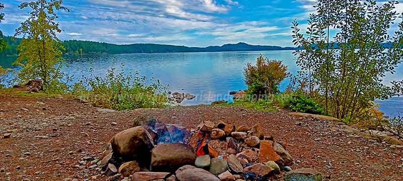 photo looking over the campfire from Petite Gosling Campground out to Campbell Lake on Vancouver Island, British Columbia Canada